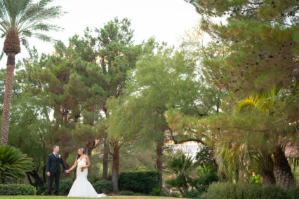 bride and groom in front of trees