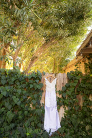 wedding dress hanging up on a fence