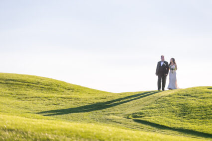 bride and groom on hill