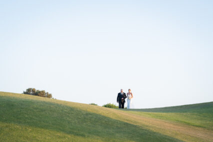 bride and groom on hill