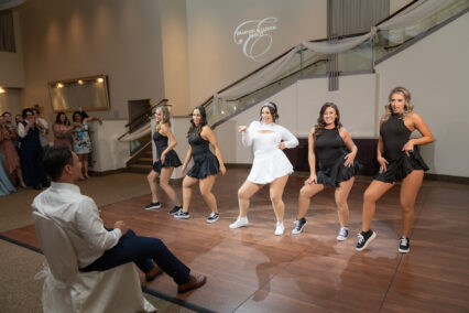 bride and bridesmaids dancing for groom