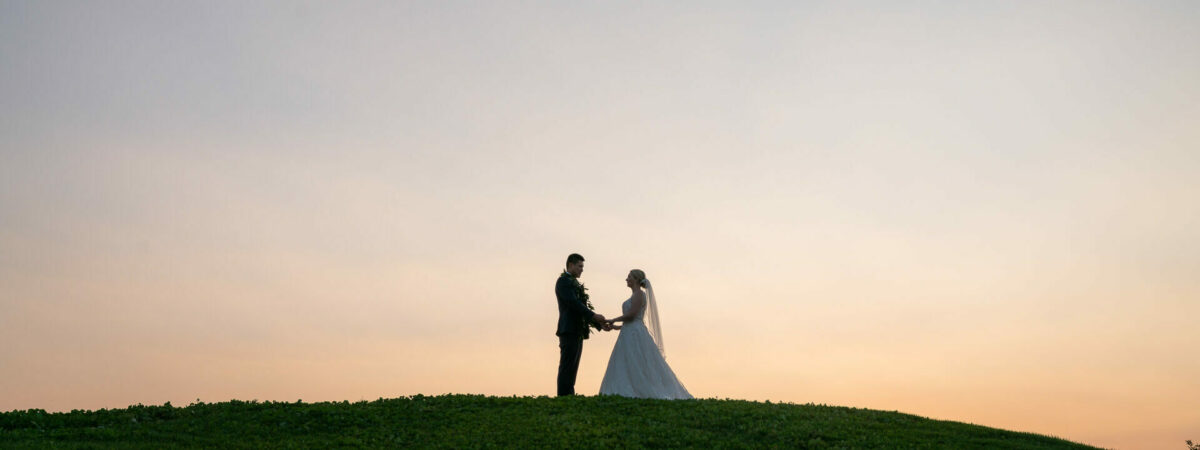 bride and groom on hill