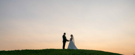 bride and groom on hill