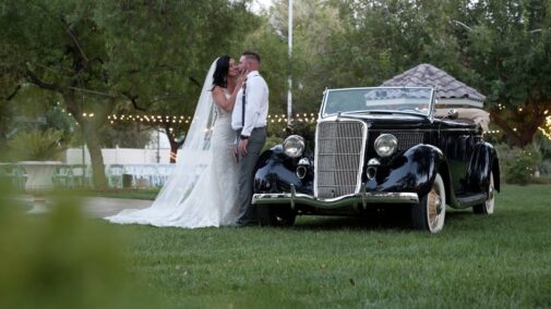 bride and groom next to car