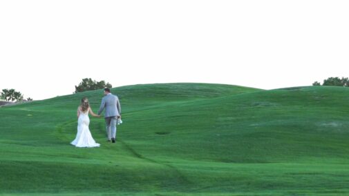 bride and groom on hill